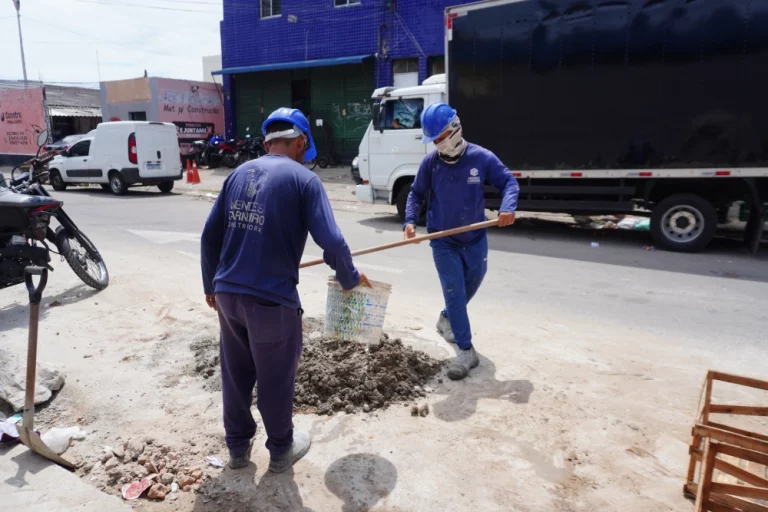 Trabalhadores fazendo traço de cimento para obra